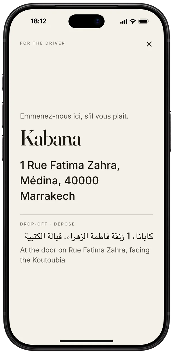 iPhone showing the card for the driver, opening in French: Kabana, 1 Rue Fatima Zahra, M&eacute;dina, in large type, with the drop-off in Arabic and English beneath
