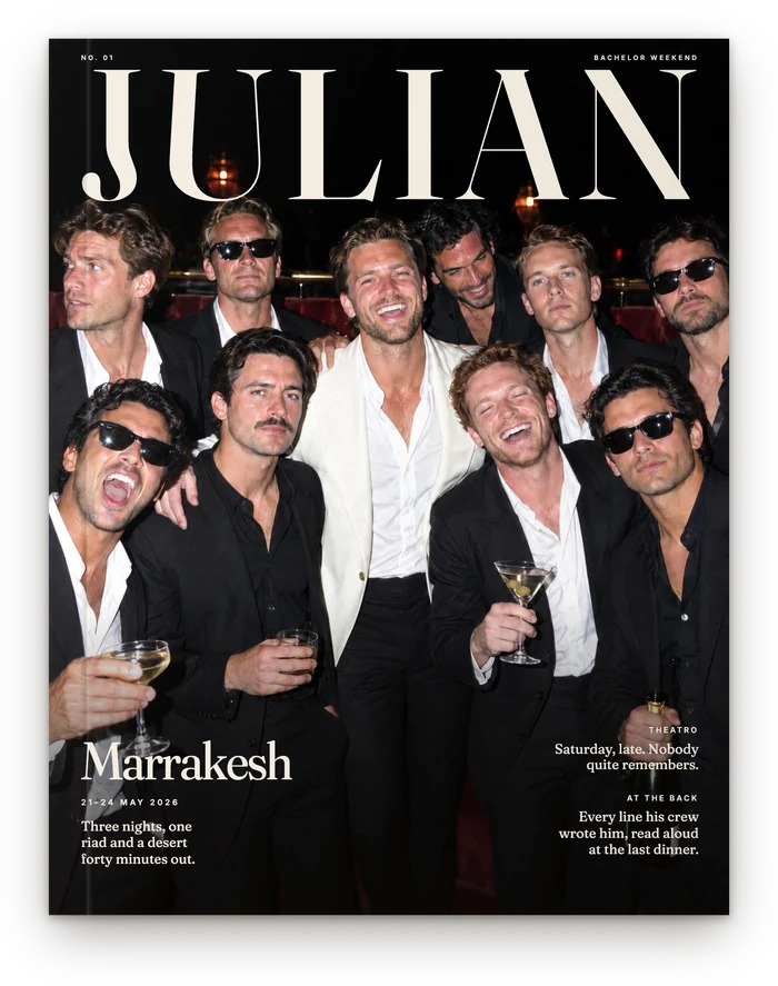 The cover, set like a magazine: JULIAN across the top, then Julian and nine friends in suits under a hard flash at a club in Marrakesh, the city and 21&ndash;24 May 2026 low on the left.